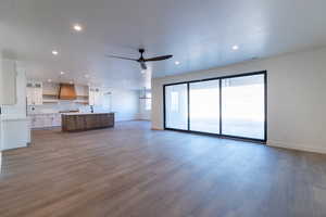 Unfurnished living room featuring ceiling fan, dark wood finished floors, and recessed lighting