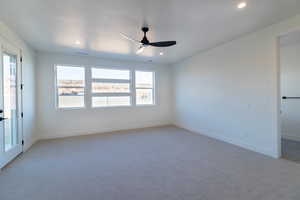Carpeted empty room with ceiling fan and recessed lighting