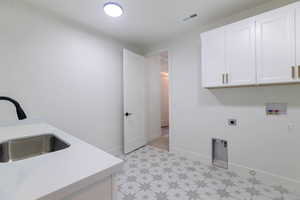 Laundry room featuring light floors, cabinet space, hookup for an electric dryer, and hookup for a washing machine