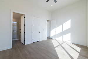 Unfurnished bedroom featuring wood finished floors, a ceiling fan, and ensuite bathroom
