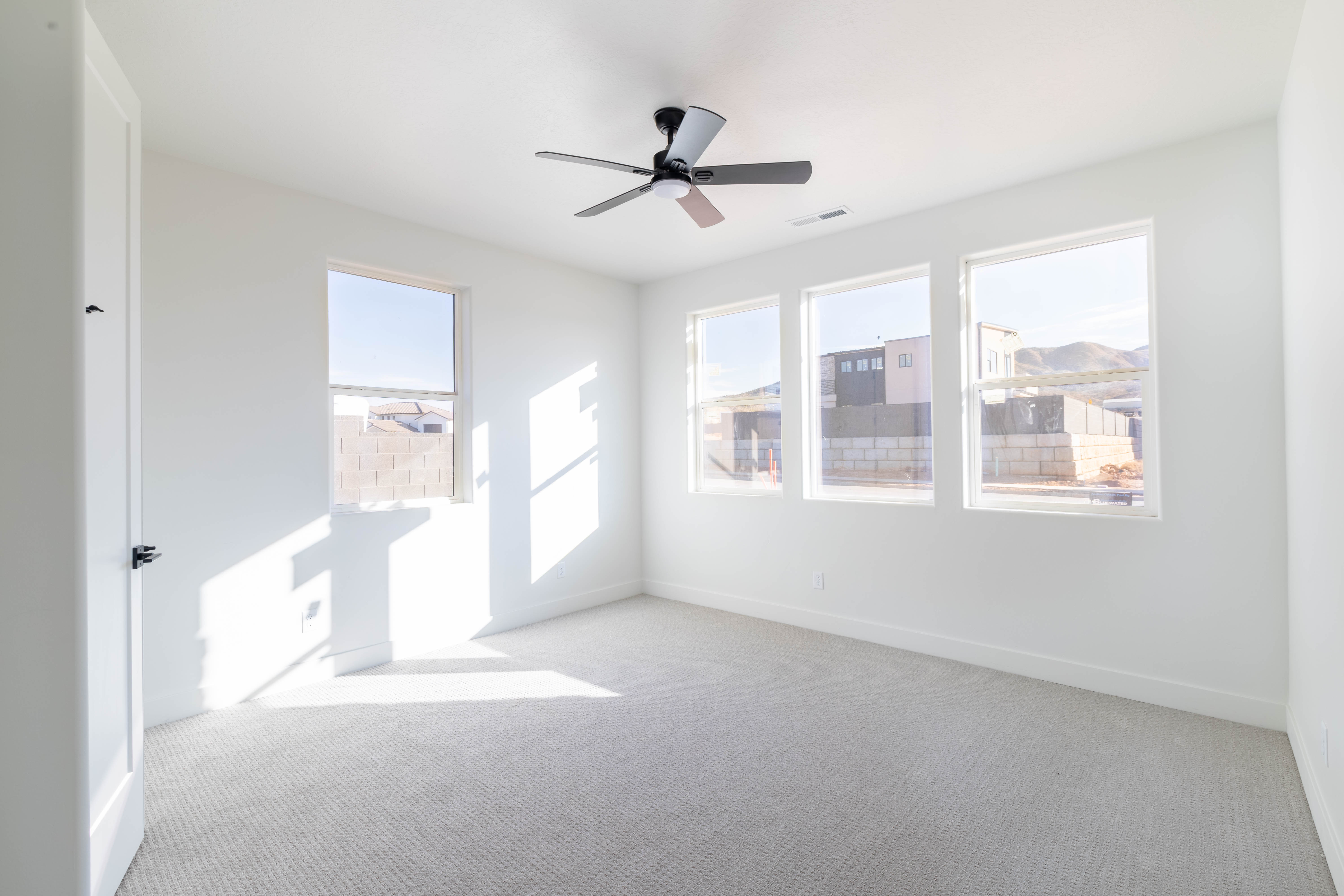Empty room featuring carpet flooring and ceiling fan