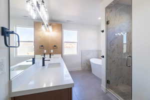 Bathroom with a soaking tub, double vanity, a marble finish shower, and recessed lighting