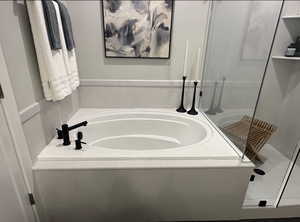 Bathroom featuring a bath and a shower stall