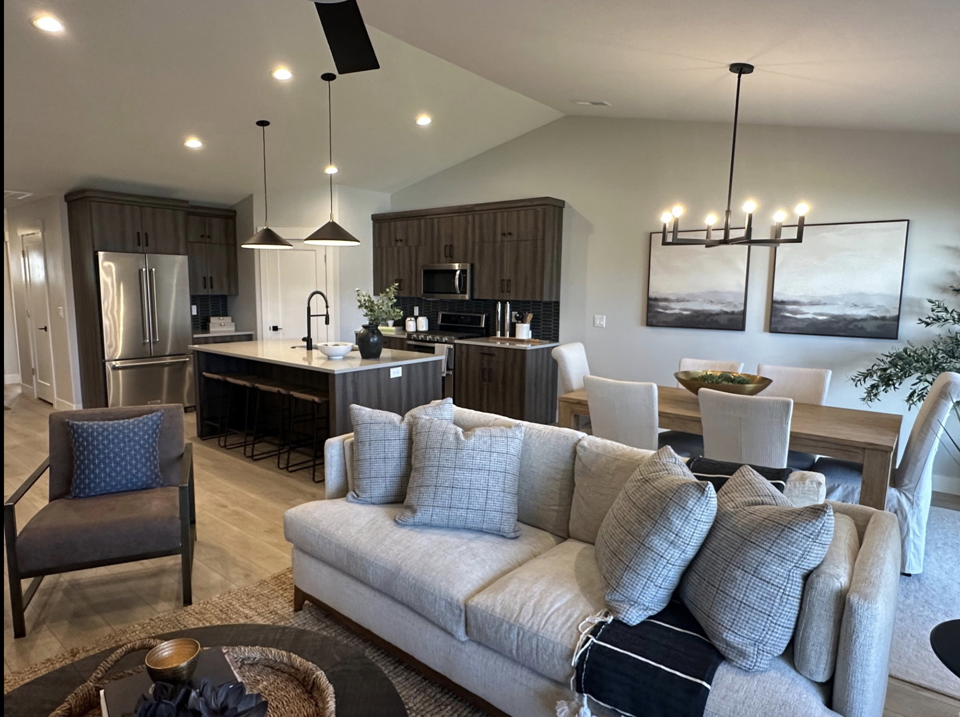 Living room with light wood-style floors, lofted ceiling, a chandelier, and recessed lighting