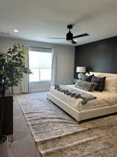 Bedroom with a textured ceiling, a ceiling fan, and carpet floors