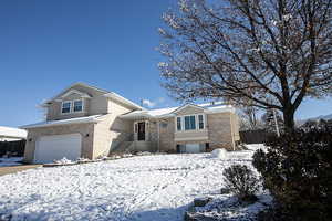 View of front of house featuring brick siding and a garage