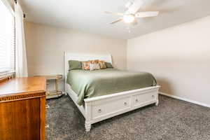 Bedroom featuring dark colored carpet and a ceiling fan