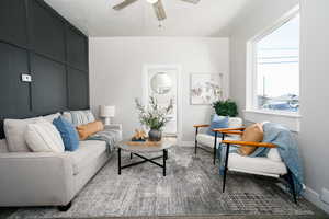 Living area featuring a ceiling fan and baseboards