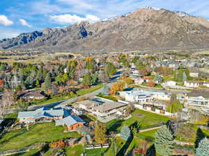 Aerial view of property's location with nearby suburban area and a mountainous background