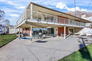 Rear view of house with a patio area, brick siding, and a mountain view