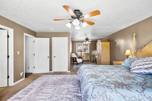 Master Bedroom with carpet floors, ceiling fan, and two closets