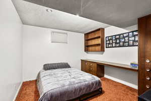 Bedroom featuring a textured ceiling and light carpet