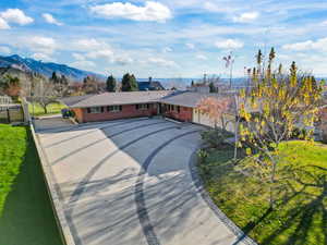 Single story home with brick siding, driveway, and a mountain view