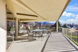 Balcony with outdoor dining space and a sunroom