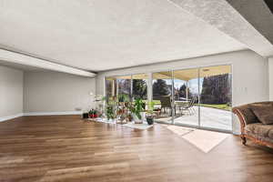 Sitting room with wood finished floors and a textured ceiling
