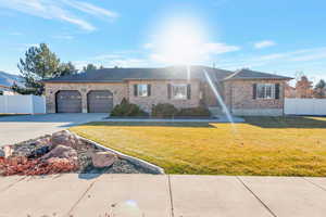 Ranch-style house featuring concrete driveway, brick siding, and an attached garage