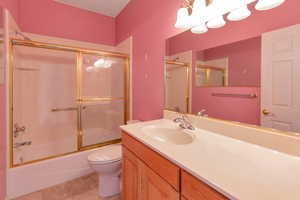 Full bathroom with shower / bath combination with glass door and vanity