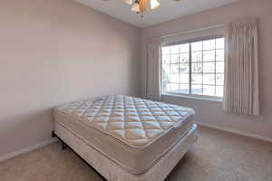 Bedroom with a ceiling fan and light carpet