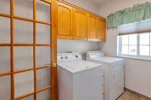 Laundry area with cabinet space and separate washer and dryer, french door