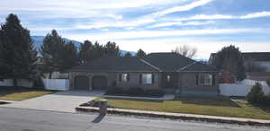 View of front of house with brick siding, driveway, and a garage