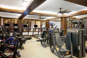 Workout area with beam ceiling, ceiling fan, and light carpet