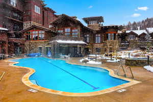 Snow covered pool featuring a community pool and a patio