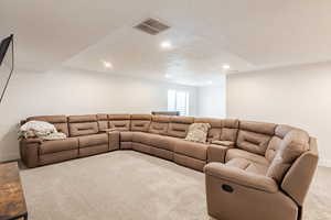 Carpeted living area featuring a textured ceiling and recessed lighting