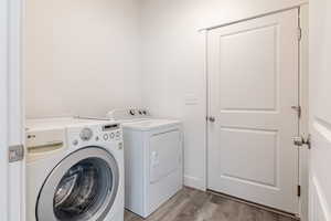 Washroom featuring light wood-style flooring and washing machine and clothes dryer