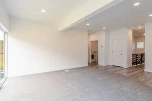 Empty room featuring recessed lighting, light colored carpet, and washer and dryer