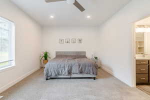 Bedroom featuring light colored carpet, connected bathroom, ceiling fan, and recessed lighting