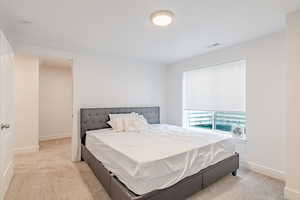 Bedroom featuring light colored carpet