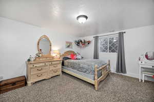 Bedroom featuring a textured ceiling and carpet floors