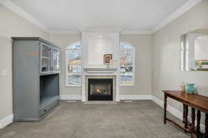 Living room with light carpet and a tiled fireplace
