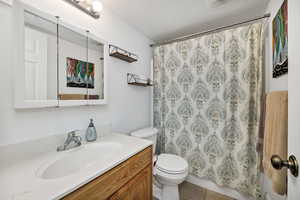 Full bathroom with vanity, tile patterned flooring, a textured ceiling, and shower / bath combination with curtain