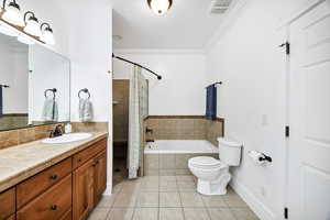 Full bathroom with a bath, crown molding, a shower stall, light tile patterned flooring, and vanity