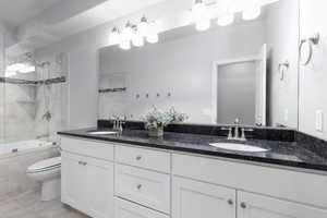 Bathroom featuring double vanity and tiled shower / bath combo