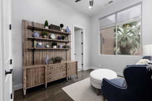 Sitting room with dark wood-type flooring and ceiling fan