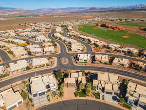 Aerial view of property and surrounding area with a mountain backdrop and nearby suburban area