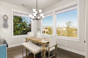 Dining area with mountain views and dark wood-style flooring, a chandelier
