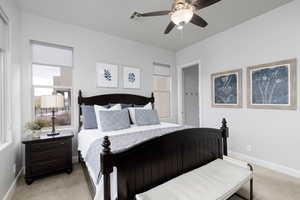 Bedroom with light colored carpet and a ceiling fan