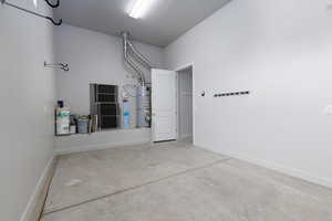 3rd bay garage featuring water heater and baseboards