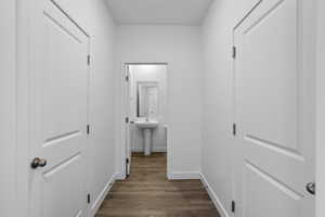 Hall featuring dark wood-style flooring and baseboards