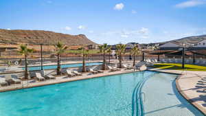 Community pool with a mountain view, a patio, and a residential view