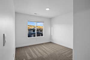 Empty room featuring carpet and baseboards