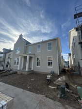 View of front facade with stucco siding and covered porch