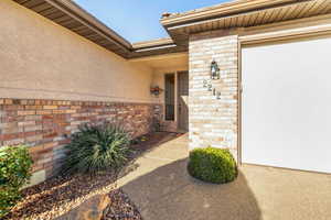 View of exterior entry with stucco siding and brick siding