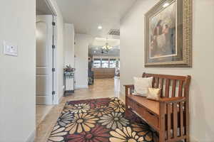 Corridor featuring a chandelier, stone tile floors, and recessed lighting