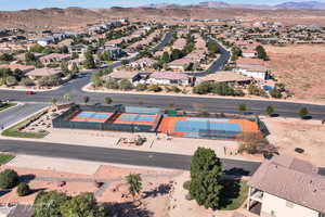 Aerial view of property and surrounding area featuring mountains and nearby suburban area