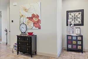Corridor featuring baseboards and stone finish floors