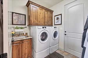 Laundry area with cabinet space and washer and clothes dryer